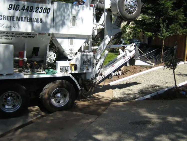 Volumetric mixer discharging into a formed excavation