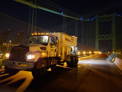 Concrete Precision Materials Mixer Truck on a bridge at night